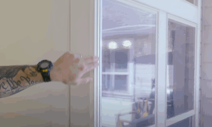 pressing gently against a glass door, highlighting the seamless finish of newly applied home window tint.