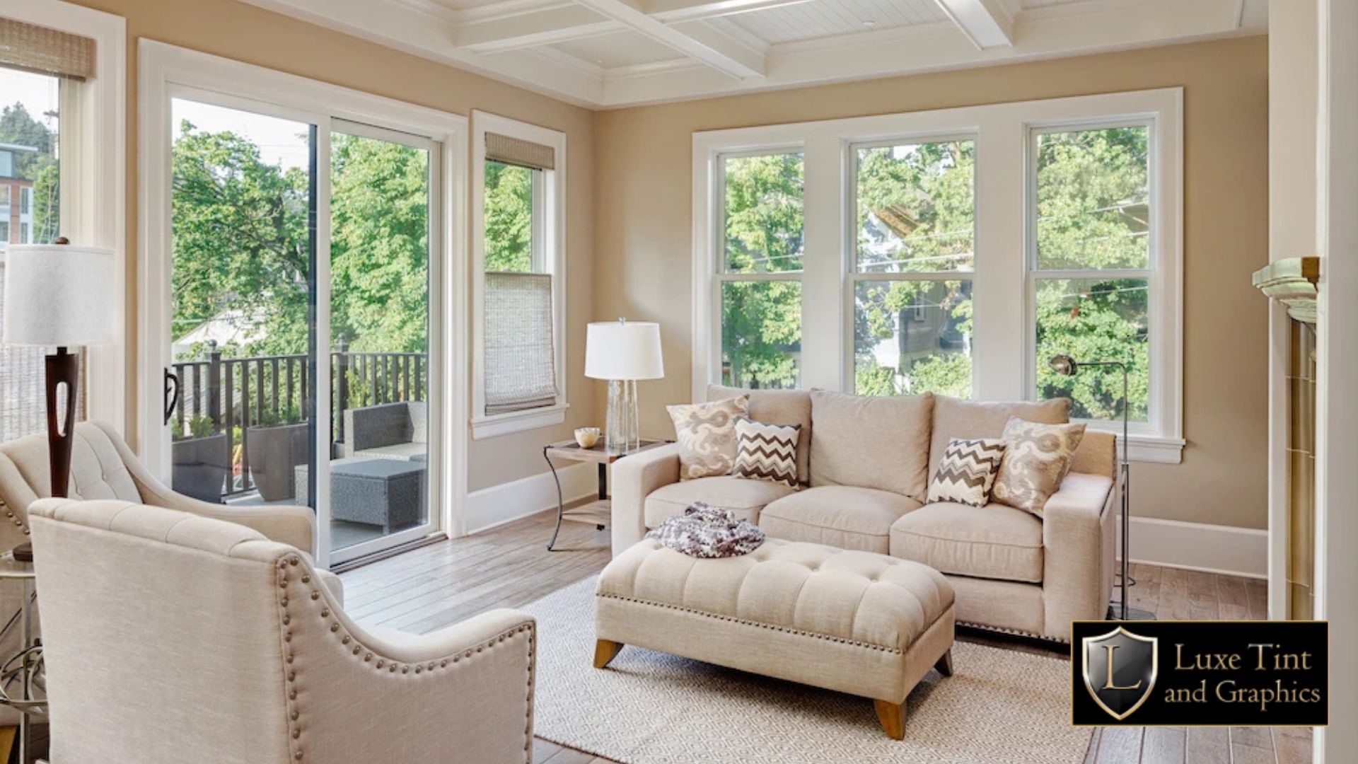 Bright, modern living room with large windows letting in natural light, subtly showcasing the clarity of professionally installed home window tint by Luxe Tint and Graphics.