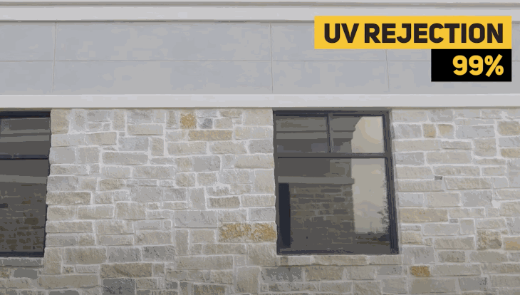 Exterior view of a commercial building with tinted windows, featuring a bold yellow graphic that reads “UV Rejection 99%.”