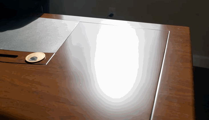 Harsh sunlight reflects off a wooden office desk, highlighting the need for commercial window tinting to reduce glare and improve comfort.